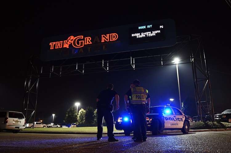 Policiais na entrada de cinema: esquadrão antibombas foi chamado para investigar um veículo que supostamente pertencia ao atirador