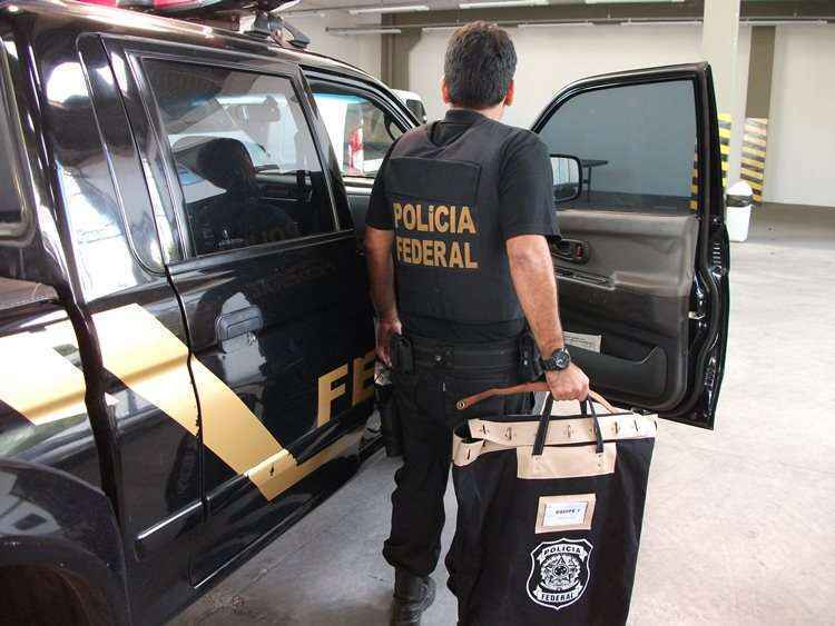 Policial com malote de documentos apreendidos durante a operação