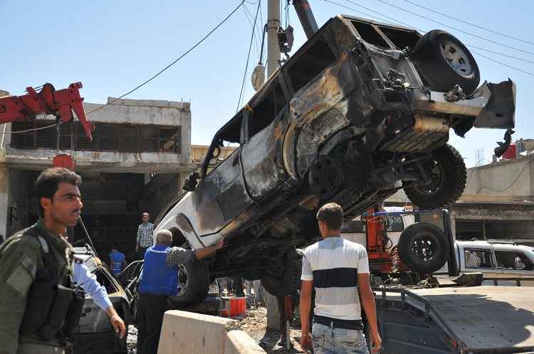 Carro atingido pela explosão sendo retirado dos escombros