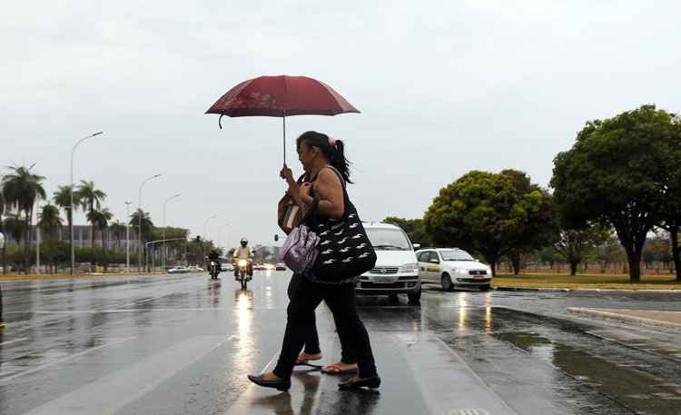 Moradores se protegem com guarda-chuva: à tarde o calor volta