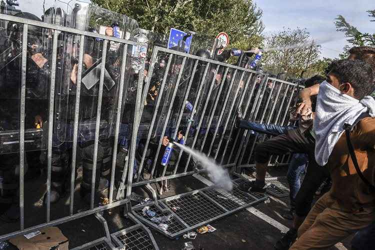 Refugiados em confronto com a polícia de fronteira da Hungria