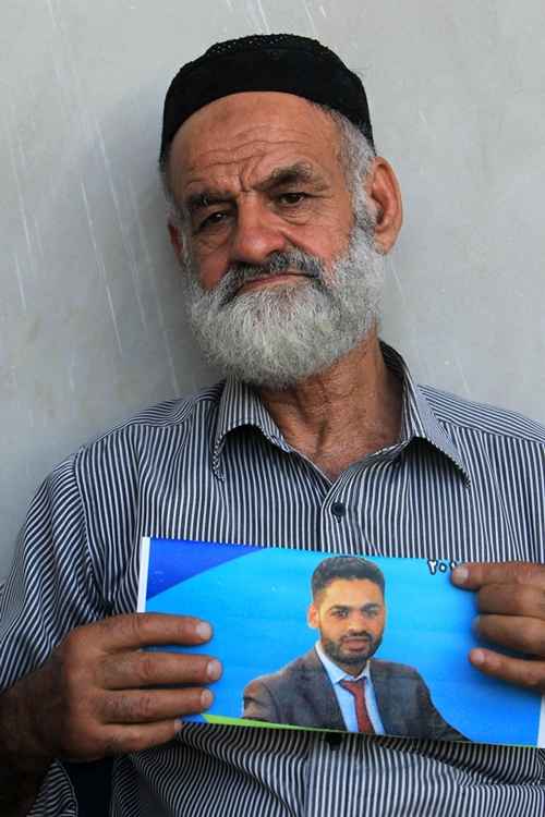 O palestino Naser al-Deen Allan segura uma foto do filho Mohammed Allan