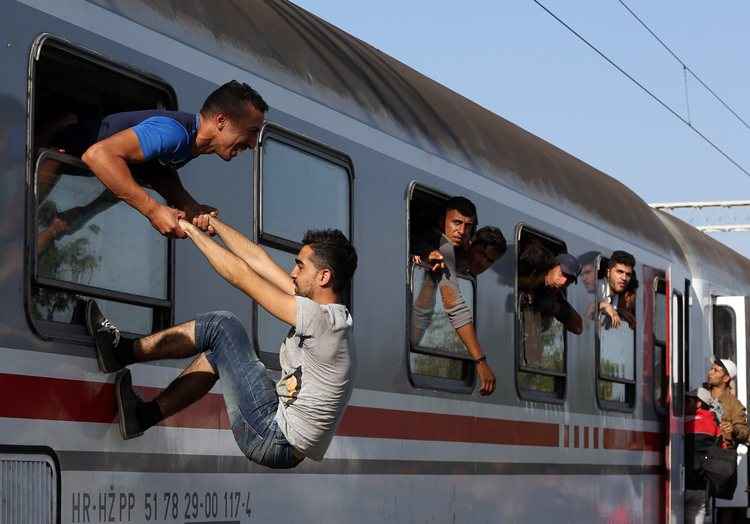 A cena tem sido recorrente durante migração. Nesta jovens escalam trem em Zagreb, Croácia