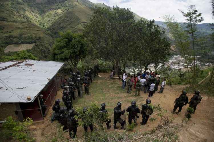 Policiais e forças armadas da Colômbia em vilarejo para proteção de ataques da Farc. Essa foi um dos últimos combates entre as duas partes antes do acordo