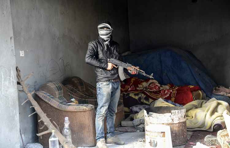 Militante do PKK segurando uma arma AK-47 durante ataques na cidade de Cizre, no sul da Turquia