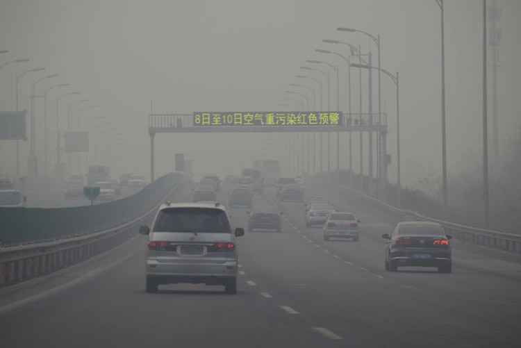 Motoristas dirigem em meio à névoa de poluição em Beijing