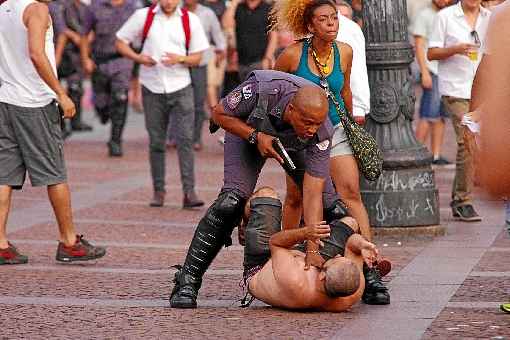 Policial aponta arma a manifestante no centro de São Paulo. Manifestação, que começou pacífica, terminou em confronto com mascarados