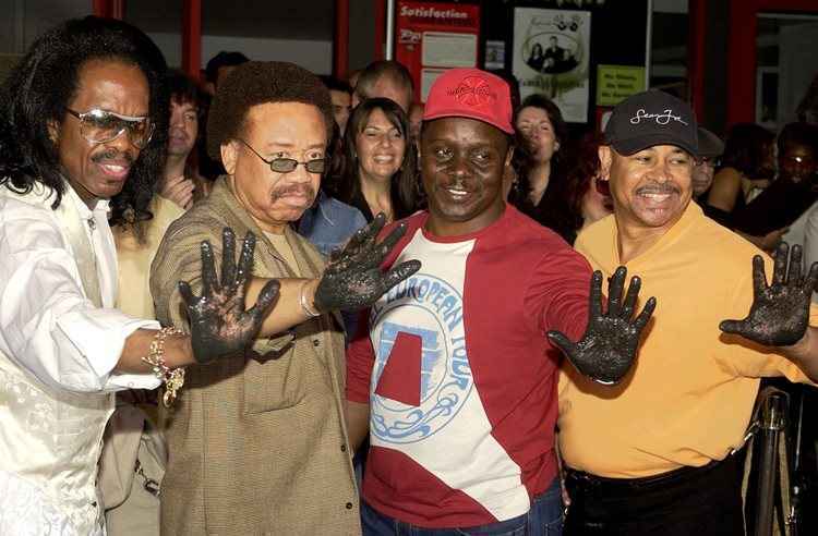 Maurice White (de terno marrom) e os outros integrantes da banda depois de deixarem sua marca na calçada da fama em Hollywood