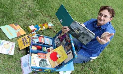 Maurício Leite tira bons livros de sua mala azul e lê para crianças. Assim, atrai a garotada para o universo da literatura