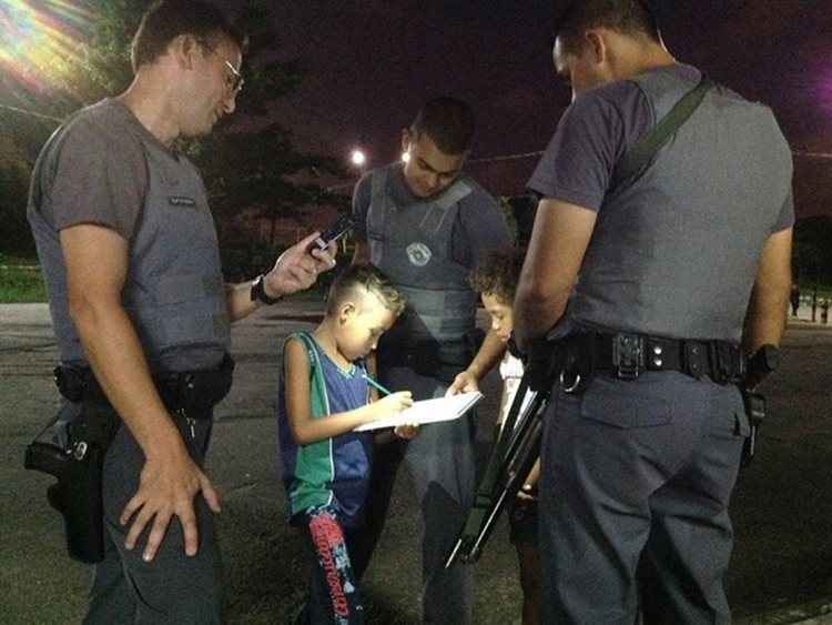 Imagem de três policiais ajudando o garoto de nove anos com a luz de uma lanterna viralizou nas redes sociais