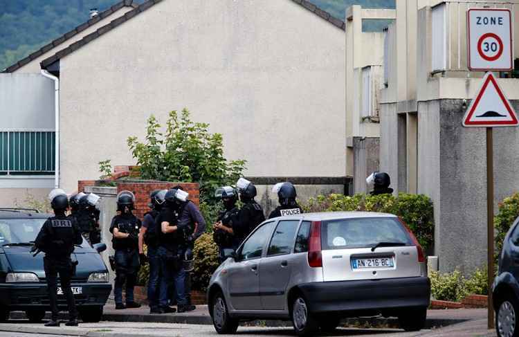 Policiais franceses ficam fora de uma casa na aldeia de Normandy de Saint-Etienne du Rouvray