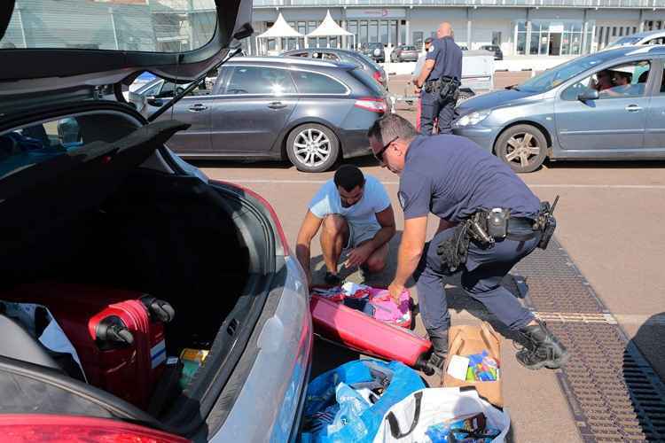 Policiais fazem vistoria em pertences de turistas que irão para o litoral francês