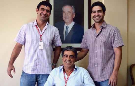 Aroldo Amorim Filho (ao centro) com os filhos Aroldo e Pedro, junto do retrato do fundador da Bonasa, Aroldo Amorim: inovação e tradição balanceadas