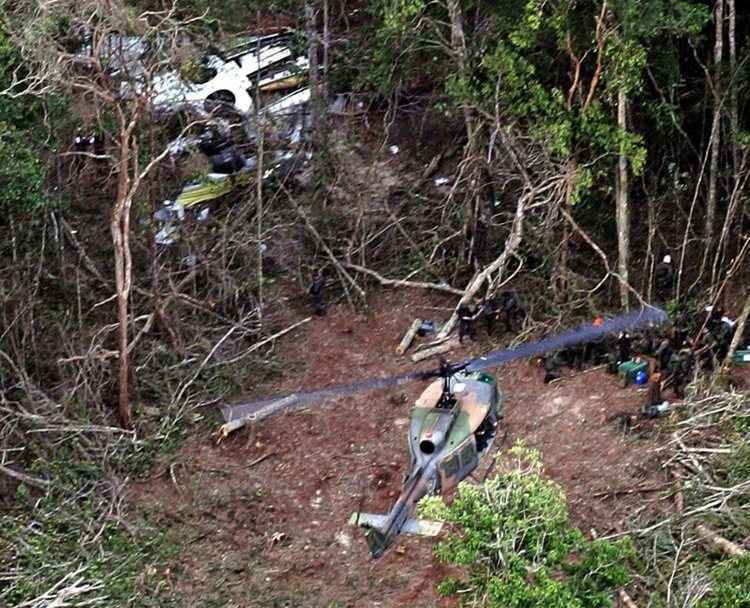 Helicóptero se aproxima de clareira para recolher corpos de vítimas