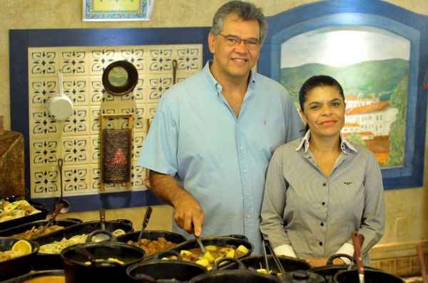 Clayton e a esposa Val, no fogão em que são servidas as comidas