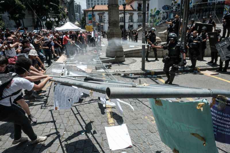 Policial dispara gás de pimenta em direção aos manifestantes que tentavam retirar grades de proteção ao prédio da Assembleia Legislativa do Rio: tensão