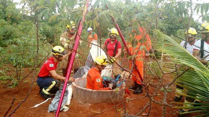 Bombeiros ao redor de cisterna durante o resgate da vítima