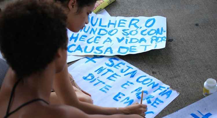 Mulheres escrevem cartazes para participar de marcha do Dia da Mulher, em Brasília