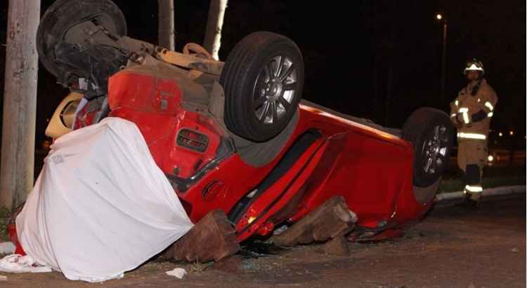 Carro vermelho capotado na rua, em Brasília