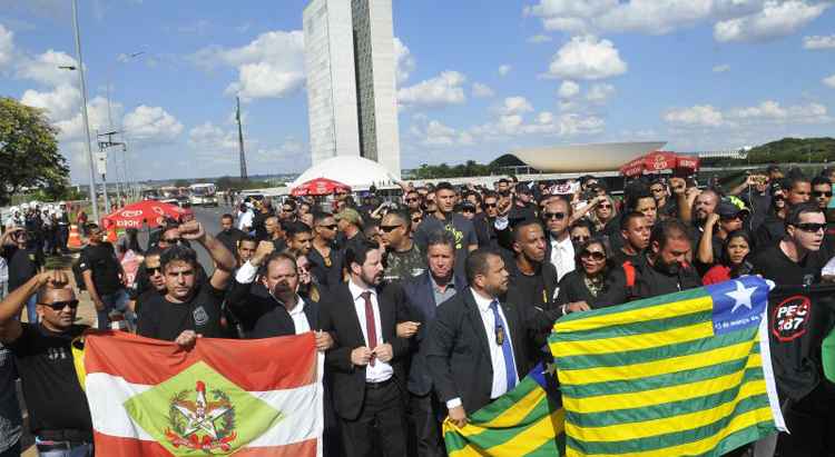 Várias pessoas com faixas e cartazes em frente ao Congresso Nacional