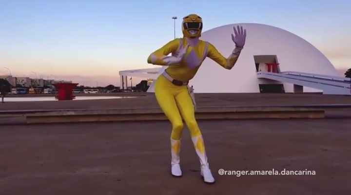 Pessoa com fantasia de Power Ranger amarelo faz pose em frente ao Museu nacional em Brasília