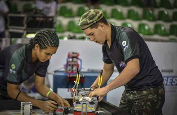 Alunos mexem em robô feito com peças de Lego