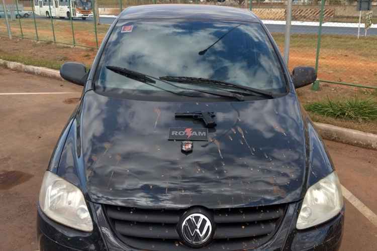 Carro preto com uma arma no capô