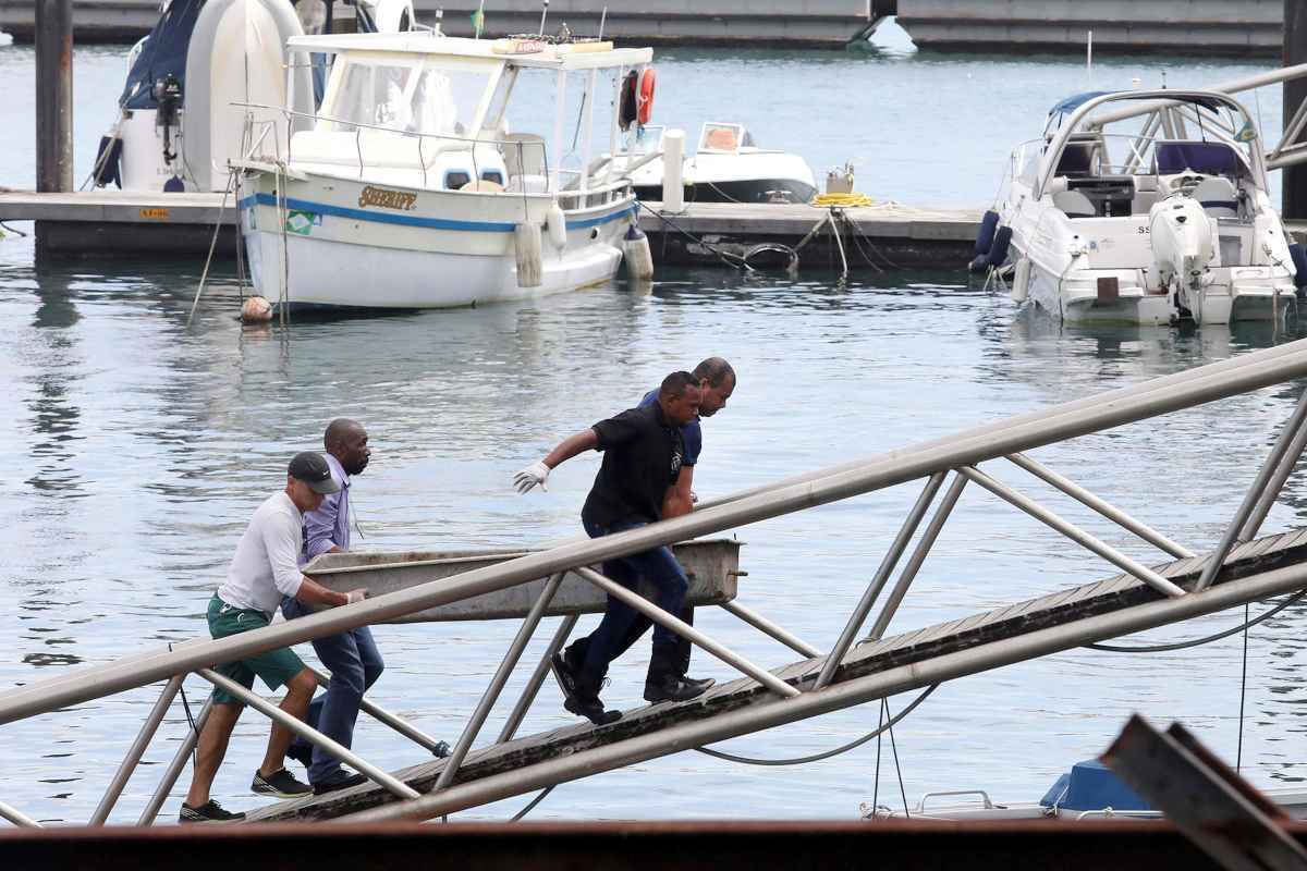 Corpo de vítima do naufrágio é carregado no terminal marítimo de Salvador