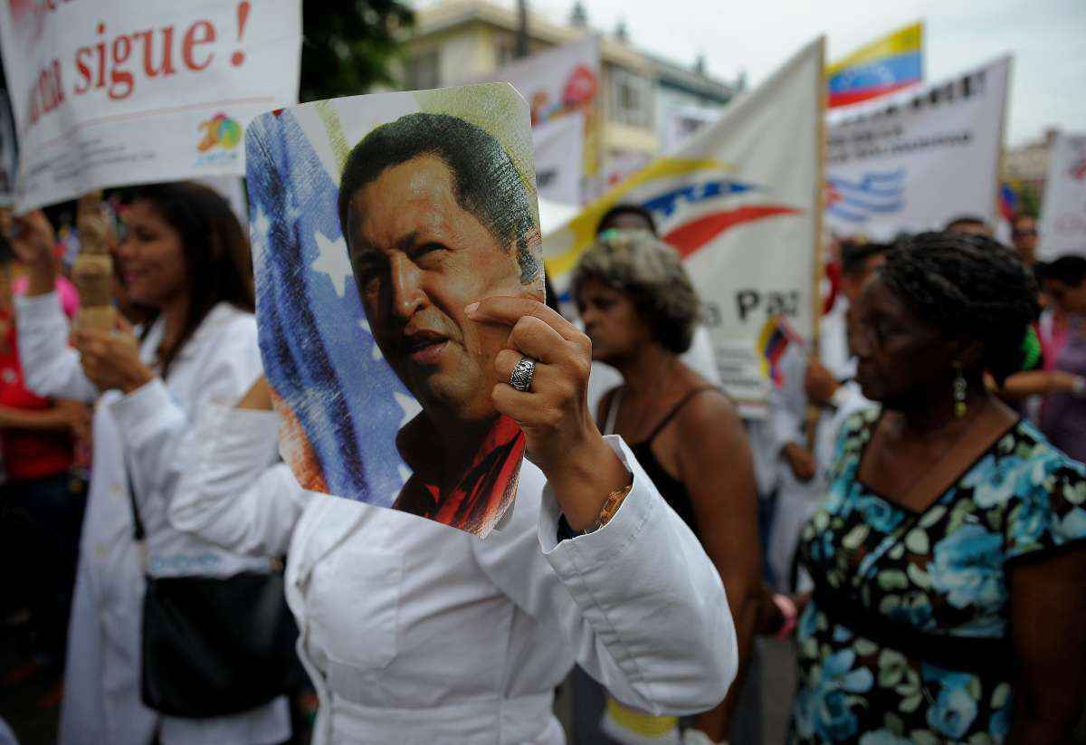 Mulher segura imagem de Hugo Chavez em protesto a favor de Maduro