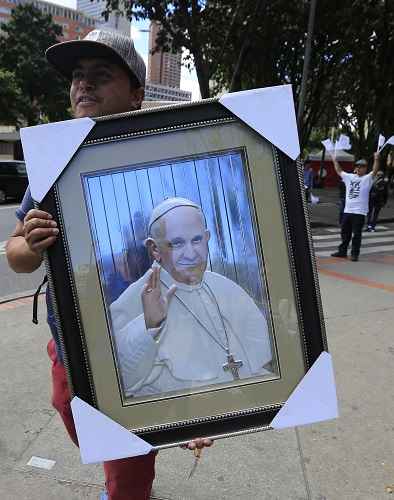 Homem carrega imagem de Francisco em Bogotá