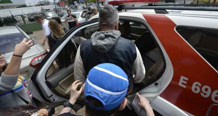 Policiais civis levam um dos acusados: ônibus circulavam com falhas graves, como rampa de acesso a cadeirantes sem funcionamento