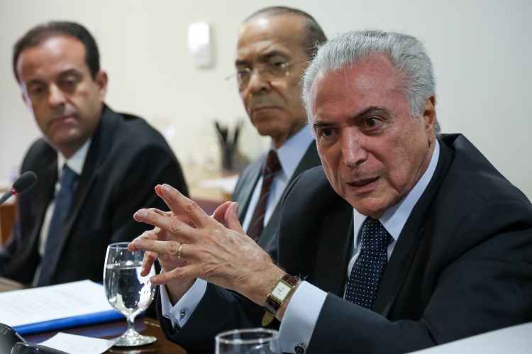 Michel Temer sentado com as mãos entrelaçadas