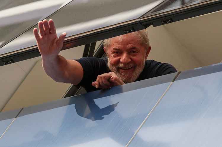 Lula acena para público por uma janela