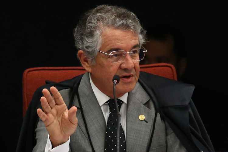 Ministro do STF, Marco Aurélio Mello sentado com um microfone na sua frente