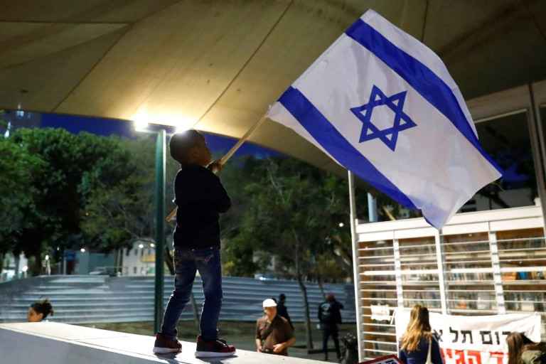 Criança segura bandeira de Israel em Tel Aviv