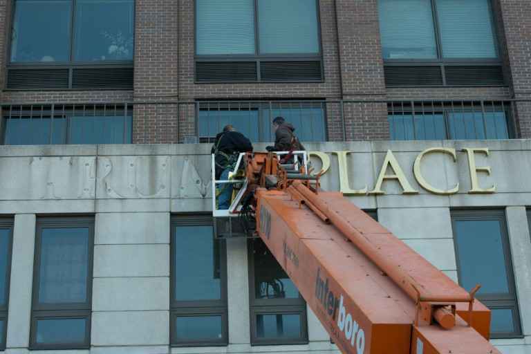 Trabalhadores retiram nome de Trump da fachada de prédio em Riverside Blvd, em Manhattan, Nova York