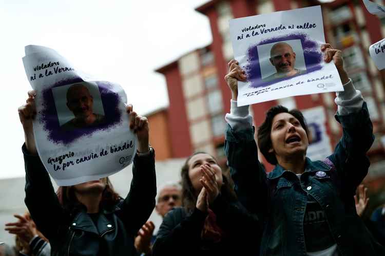 Manifestantes seguram cartazes com a foto de condenado por estupro Gregorio Cano Beltri, em Barcelona