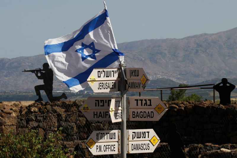 Soldados armados atrás de uma bandeira de Israel