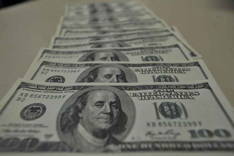 Várias notas de dólar em cima de uma mesa