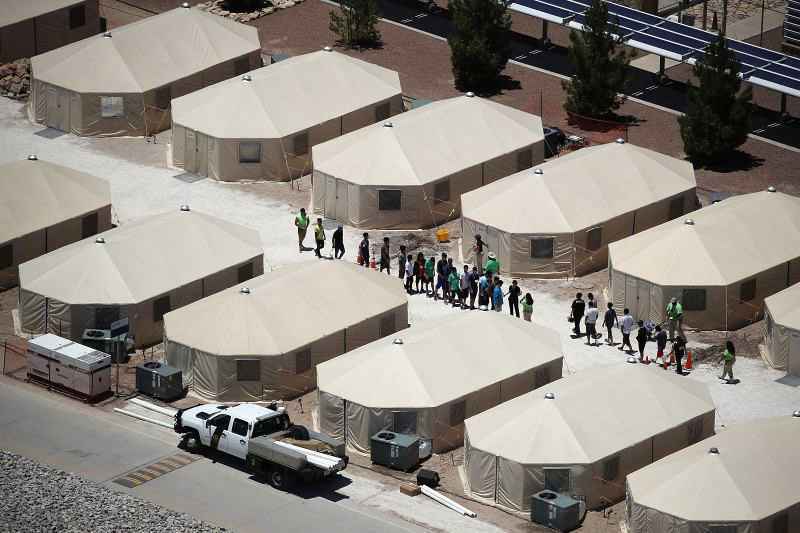 Crianças e trabalhadores são vistos em um acampamento de tendas construído recentemente perto do Porto de Entrada de Tornillo em 19 de junho de 2018, em Tornillo, Texas