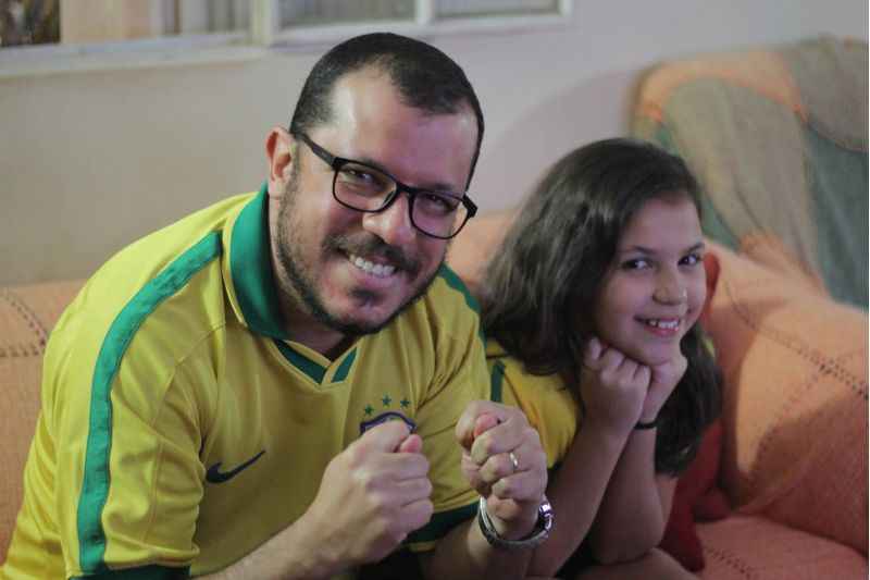 O historiador João Jambeiro acompanha as partidas do Brasil na Copa ao lado da mãe e da filha: de mãos dadas, rezam e fazem figa enquanto assistem ao jogo em frente a TV