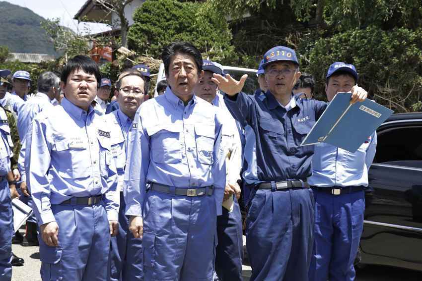 Shinzo Abe rodeado de pessoas