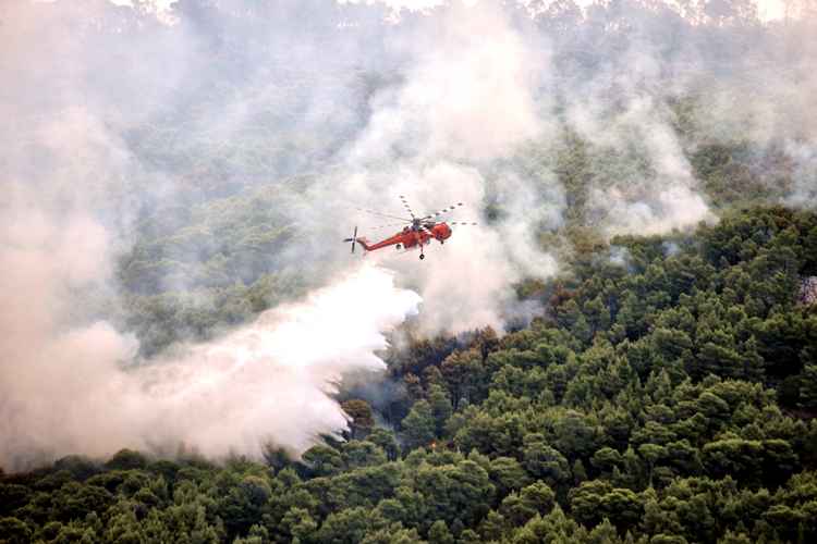 Helicóptero tentando apagar as chamas do incêndio