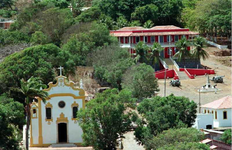 Igreja Nossa Senhora dos Remédios e ao fundo a Fortaleza Nossa Senhora dos Remédios, na Vila dos Remédios