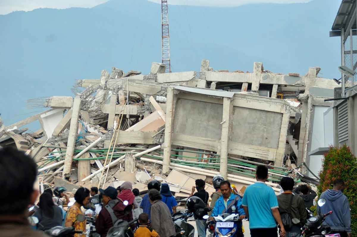 Moradores observam prédio que desabou com terremoto na Indonésia