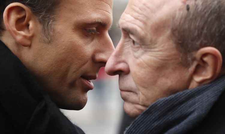 Nesta foto tirada em 7 de janeiro de 2018, o presidente francês Emmanuel Macron (L) conversou com o ministro do Interior, Gerard Collomb (R), depois de uma cerimônia em frente ao supermercado Hyper Casher, como a França presta homenagem aos compradores. loja kosher que foram mortos há três anos por um atirador islâmico em Paris.