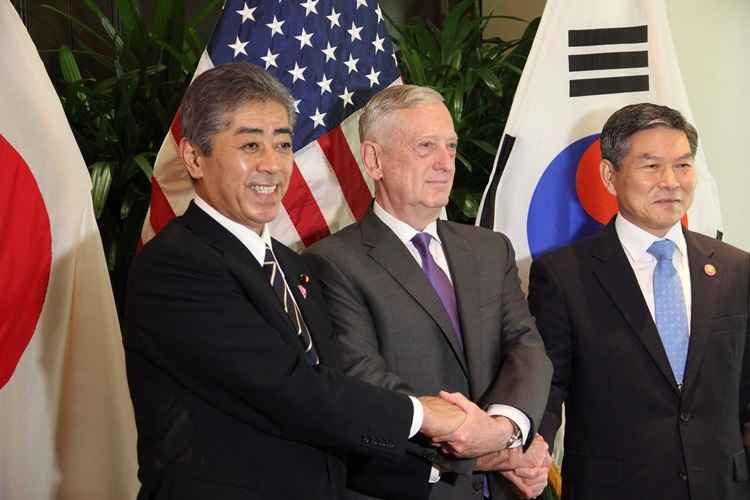 O ministro da Defesa do Japão, Takeshi Iwaya, o ministro da Defesa dos EUA, Jim Mattis, eo ministro da Defesa da Coréia do Sul, Jeong Kyeongdoo, dão as mãos durante uma sessão de fotos antes de uma reunião tri-lateral na Associação das Nações do Sudeste Asiático.