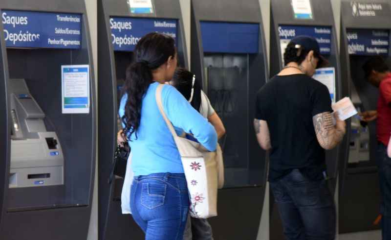 Homem e mulher em frente a caixa eletrônico