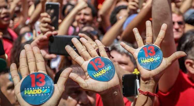 Mãos de eleitores com adesivos de Haddad