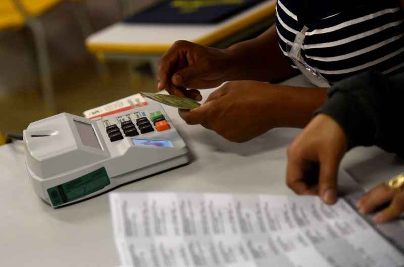 Eleitores usam a biometria antes de entrar na cabina de votação